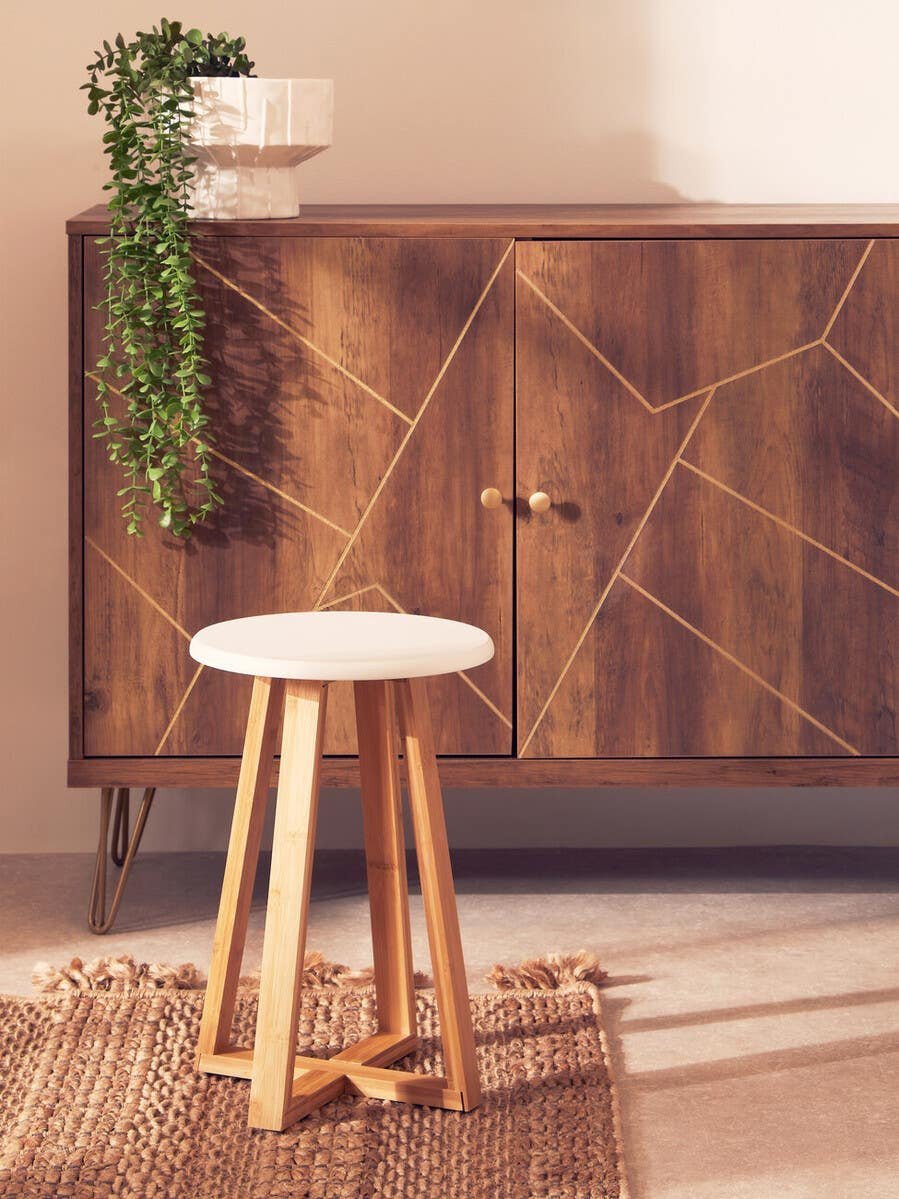Stool in a calm, contemporary interior setting next to storage unit, stool close up