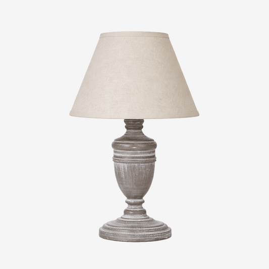 Urn style table lamp with a grey base and light beige linen shade